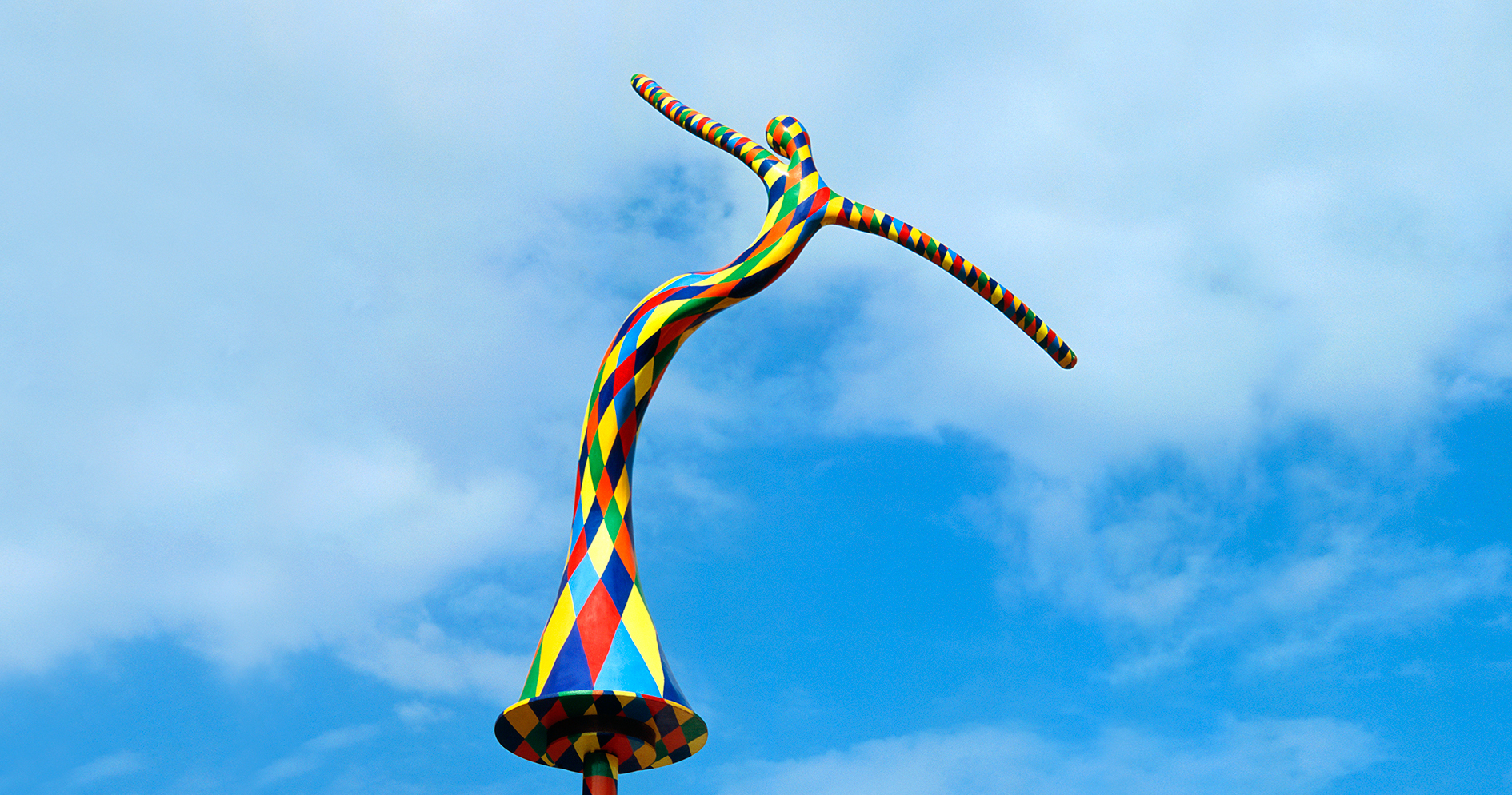 Vassiliki — harlequin figure installation against the sky